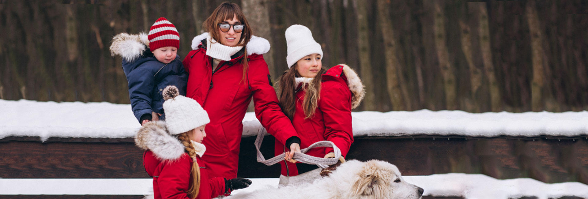 Familia con estilo en la nieve y perro blanco